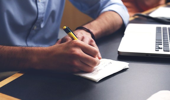A person is writing a note
