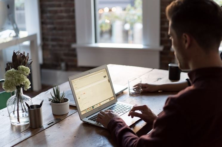 A person is working on the laptop at home