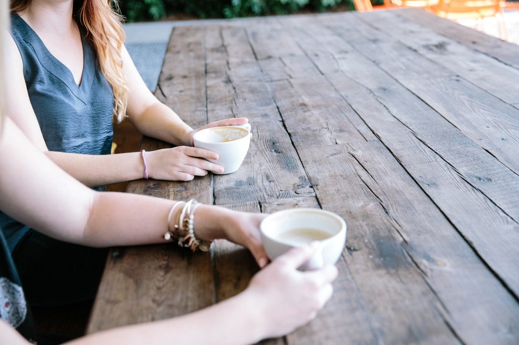 2 person is chatting while having coffee