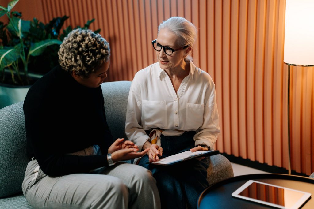 Two people seated and engaged in a serious discussion.