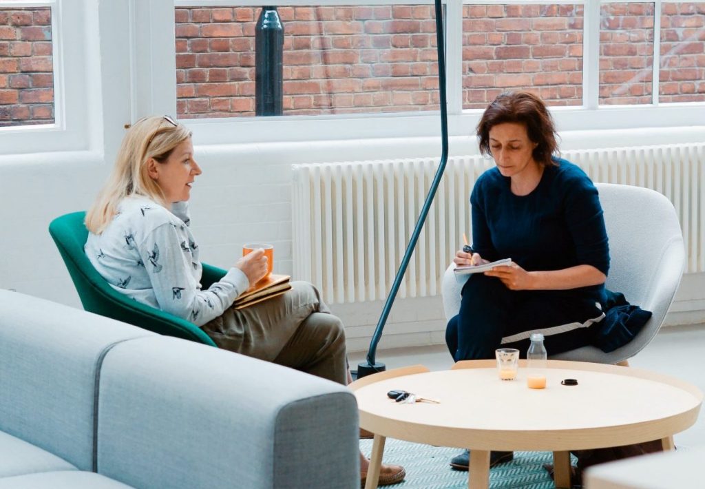 Two people seated at a small table resolving conflict.