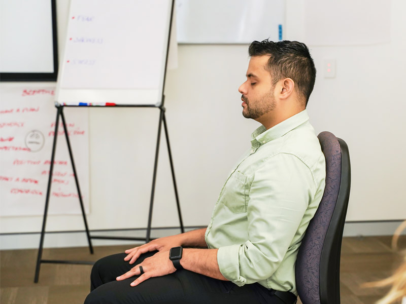 A person seated participating in a mindfulness activity.