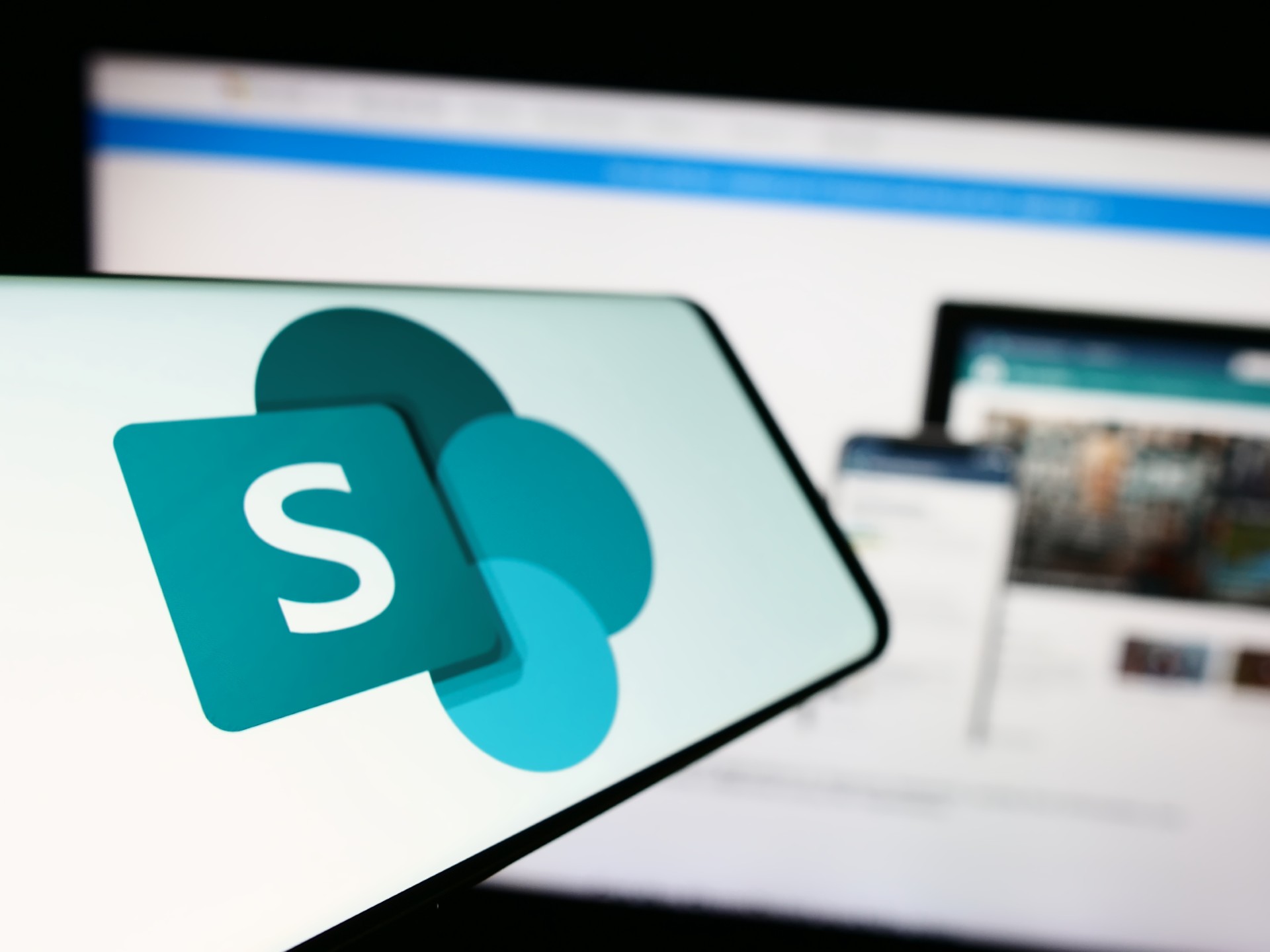 SharePoint logo on the mobile and PC screen on the background.
