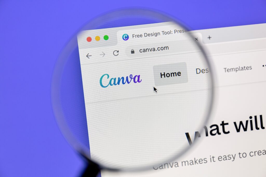 Canva website on the laptop screen with a magnifying glass focus on the logo