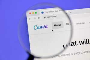 Canva website on the laptop screen with a magnifying glass focus on the logo