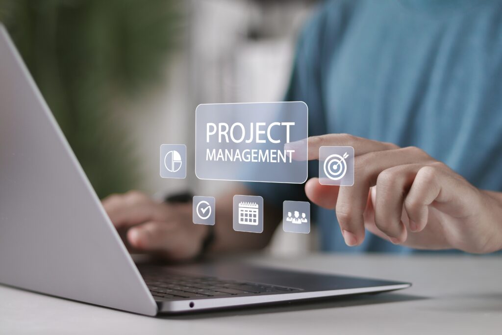 Zoom in of a person hand typing on the laptop with Project Management mind map floating in the middle.